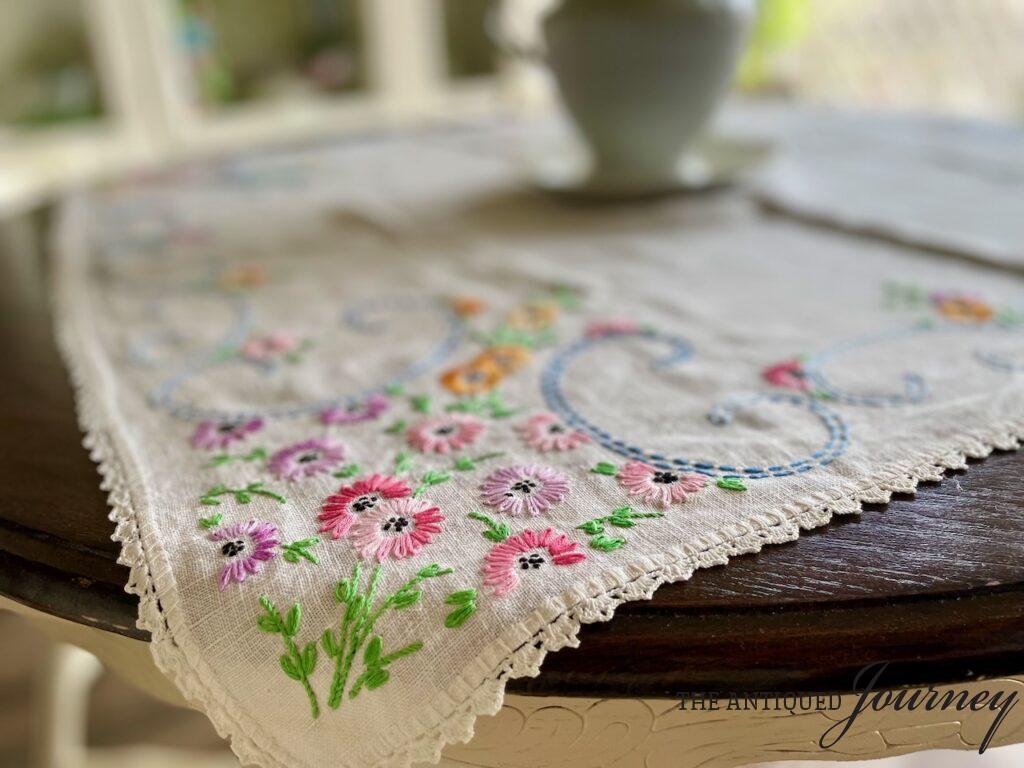 a thrifted table linen with embroidered flowers