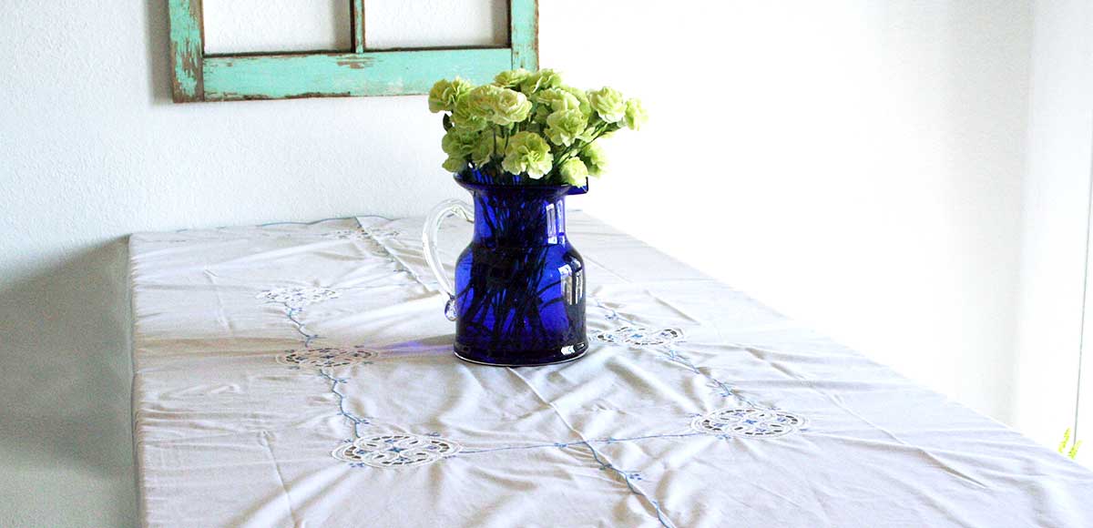 a vintage blue vase filled with green flowers