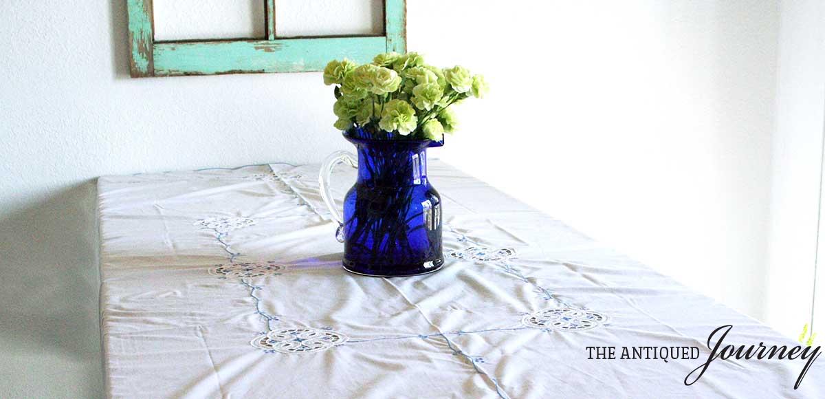 a vintage blue vase filled with green flowers
