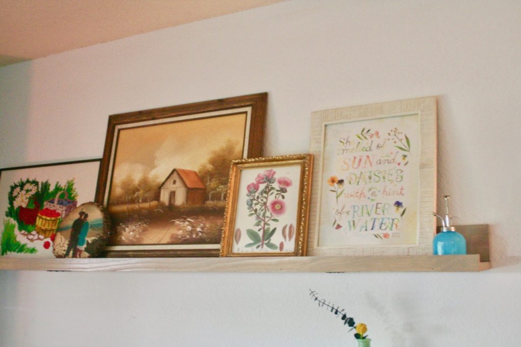 vintage art displayed on a picture rail