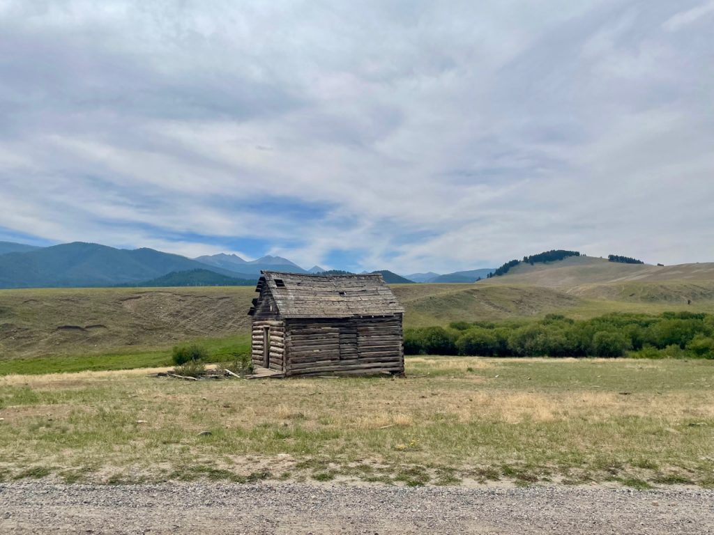 an old worn log cabin in the mountains