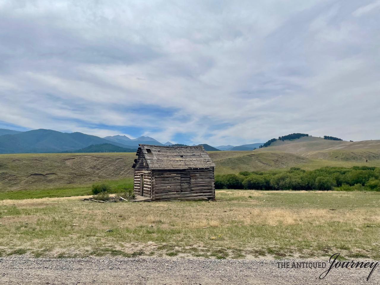 an old worn log cabin in the mountains