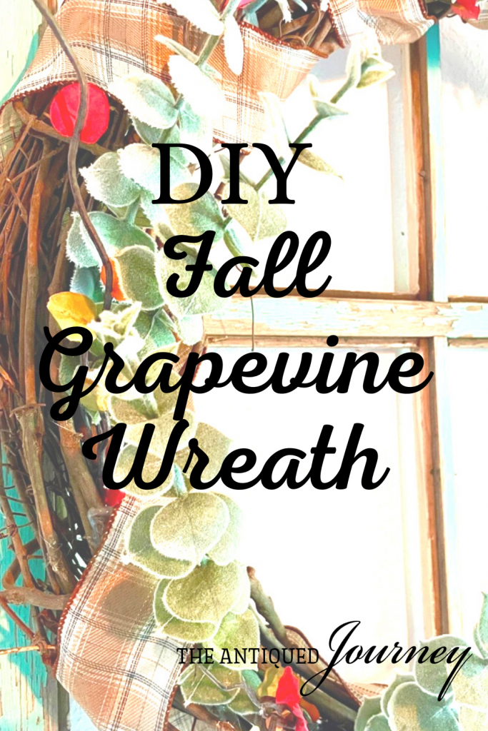 fall grapevine wreath displayed on a vintage window