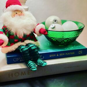 a vintage santa sitting next to a vintage glass bowl