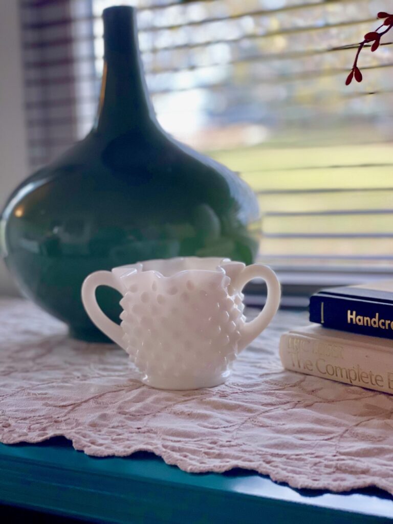 a vintage milk glass sugar jar in a vignette