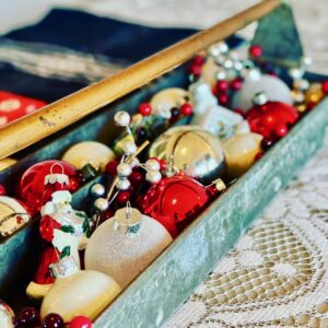 an antique toolbox filled with vintage Christmas ornaments
