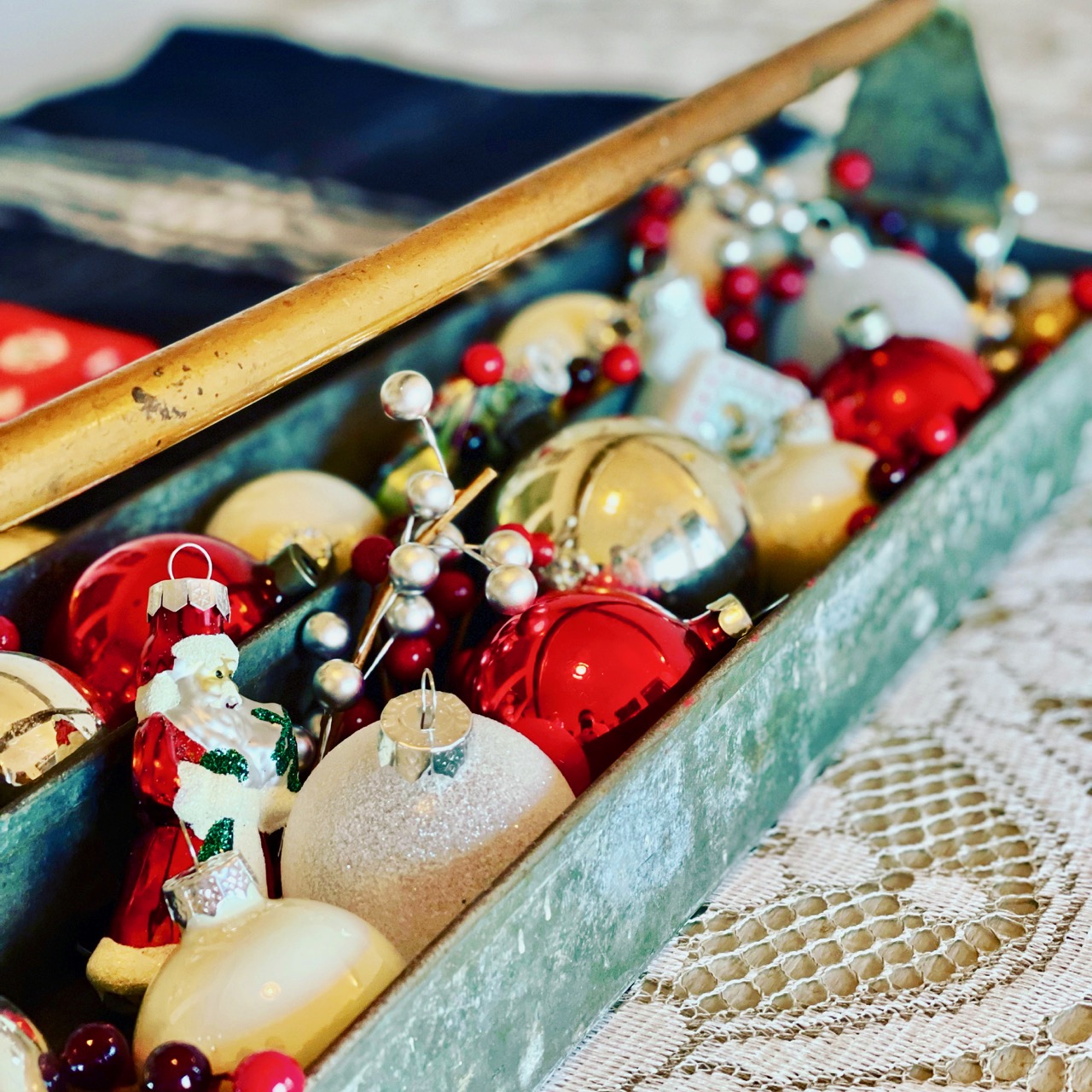 an antique toolbox filled with vintage Christmas ornaments