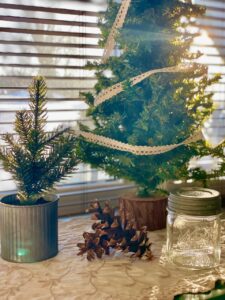 a small winter vignette with trees and a vintage jar