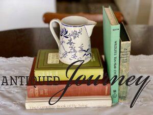 vintage books stacked with a vintage pitcher for a centerpiece