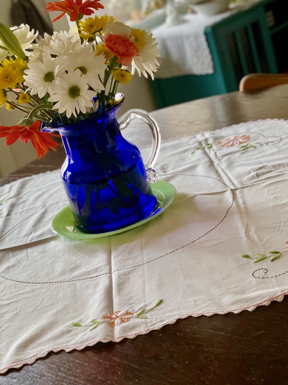 a vintage floral embroidered table linen with fresh flowers