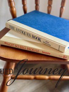 two vintage hardcover books stacked on a chair