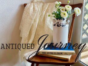two vintage books displayed on a chair with faux flowers and lace