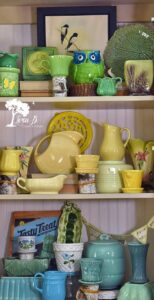 a collection of vintage dishes displayed in a hutch