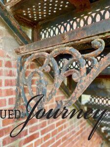 a decorative iron bracket under a staircase outside