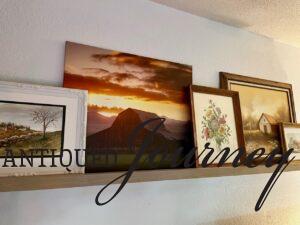 a picture rail that is displayed with modern art and framed vintage art