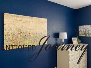 a large canvas art picture of wildflowers on a blue bedroom wall
