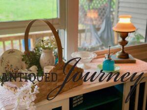 a vintage basket used to hold a summer vignette with vintage pieces