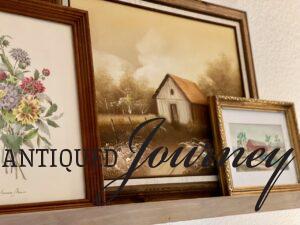a picture rail that holds vintage art in frames