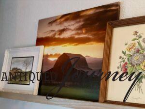 vintage and modern art displayed together on a picture rail
