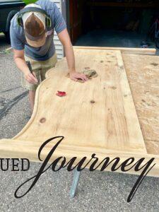 sanding the top of a vintage wooden headboard