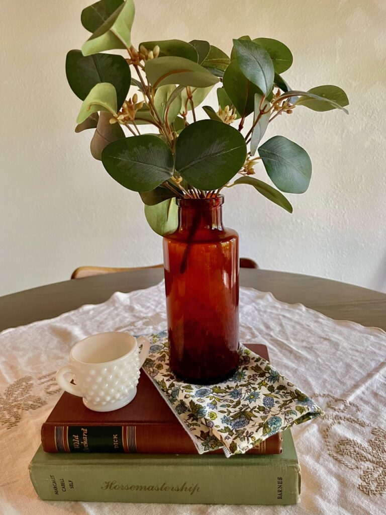 a vintage amber bottle displayed with vintage books