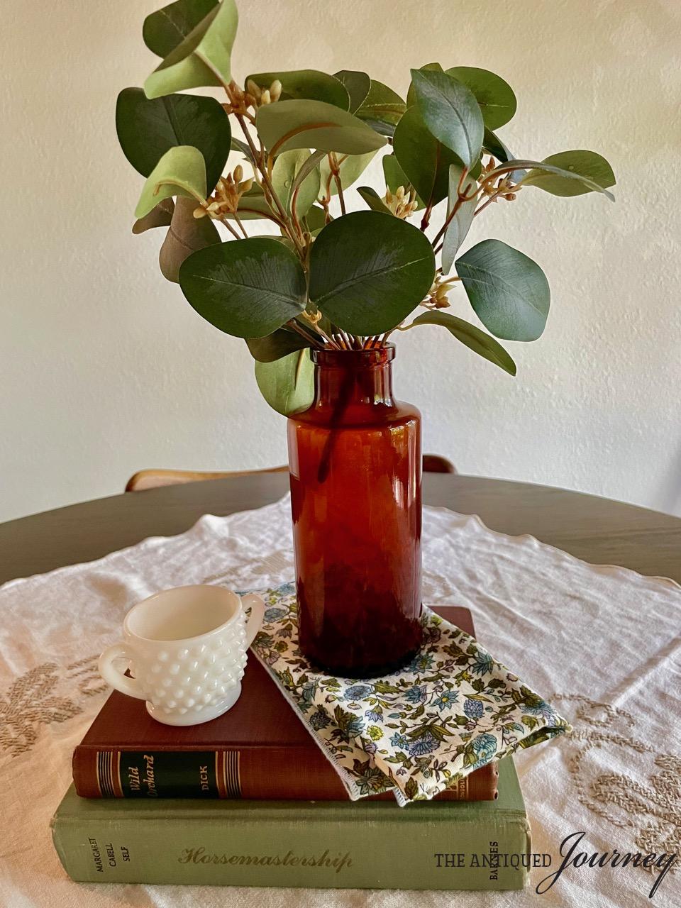 a vintage amber bottle displayed with vintage books