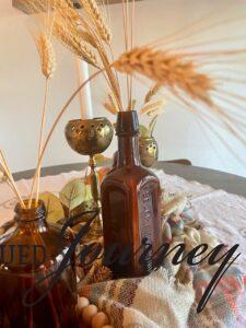decorative wheat stems displayed in amber bottles for fall