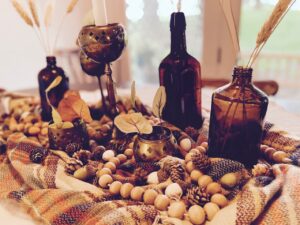 a fall centerpiece featuring amber bottles and vintage brass