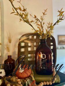 an amber bottle displayed with a vintage tobacco basket for fall