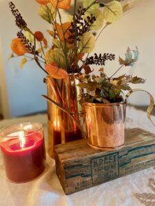 a centerpiece with thrifted vintage copper and a candle for fall