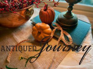 a plaid ribbon displayed with some faux pumpkins for fall