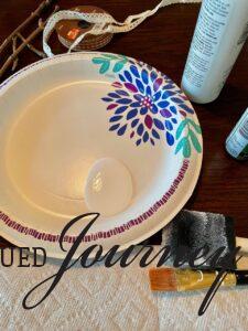 white craft paint on a paper plate