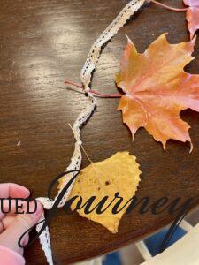 fall leaves tied onto a ribbon for a garland