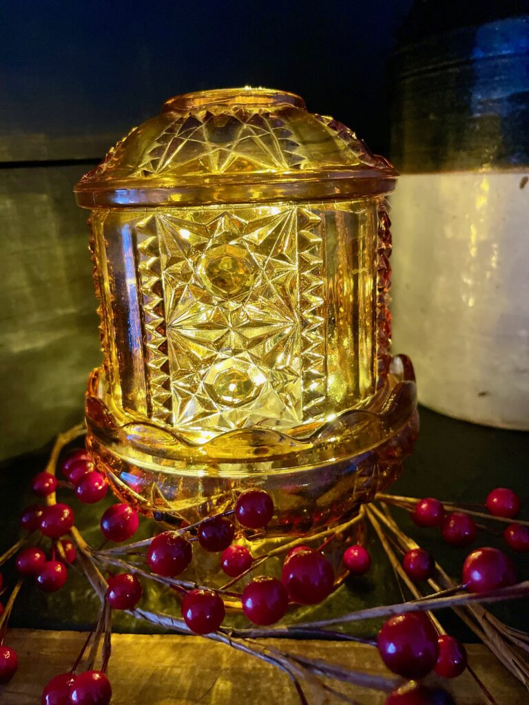 a vintage amber fairy light with red berries on a mantel