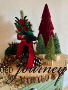 a Christmas tray with velvet, faux trees, and pinecones