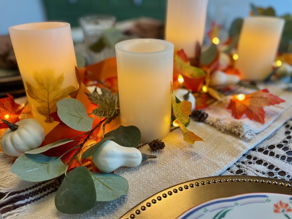 a Thanksgiving table scape with candles and thrifted finds