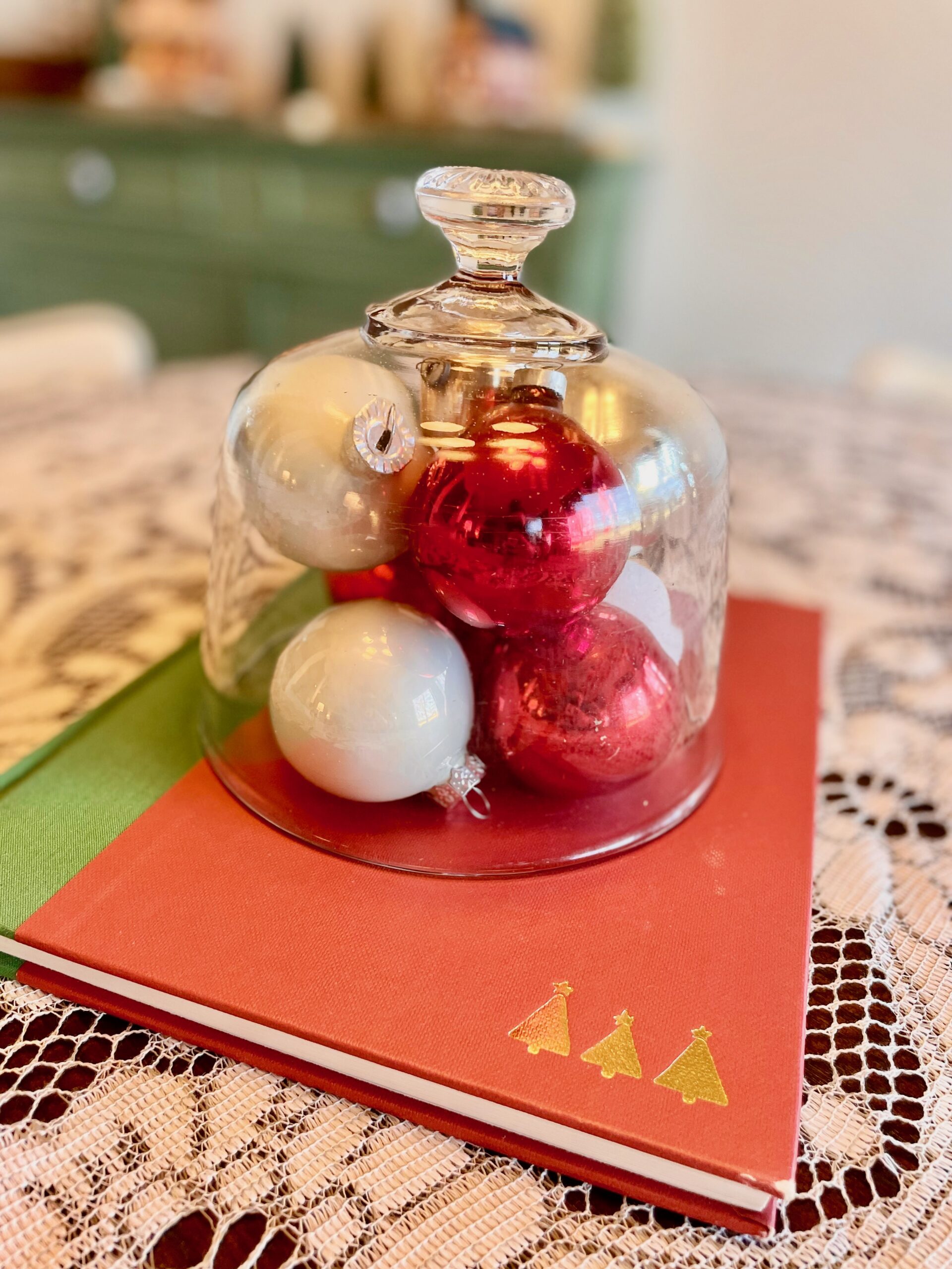 a Christmas centerpiece with vintage ornaments and a book