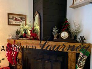 a mantel decorated for Christmas with velvet and faux trees