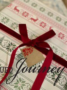 a DIY stamped Christmas gift tag on a present with velvet ribbon