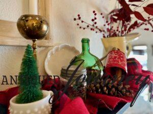 a Christmas display with vintage jars and brass