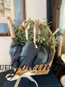 a winter mantel display with a basket, candle, and milk glass