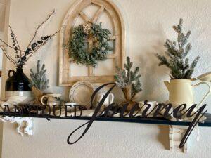 a wall shelf decorated for winter with blues, greens, and creams
