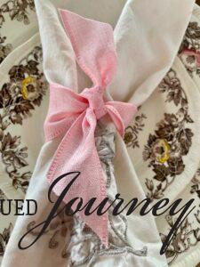 a vintage napkin with a pink ribbon
