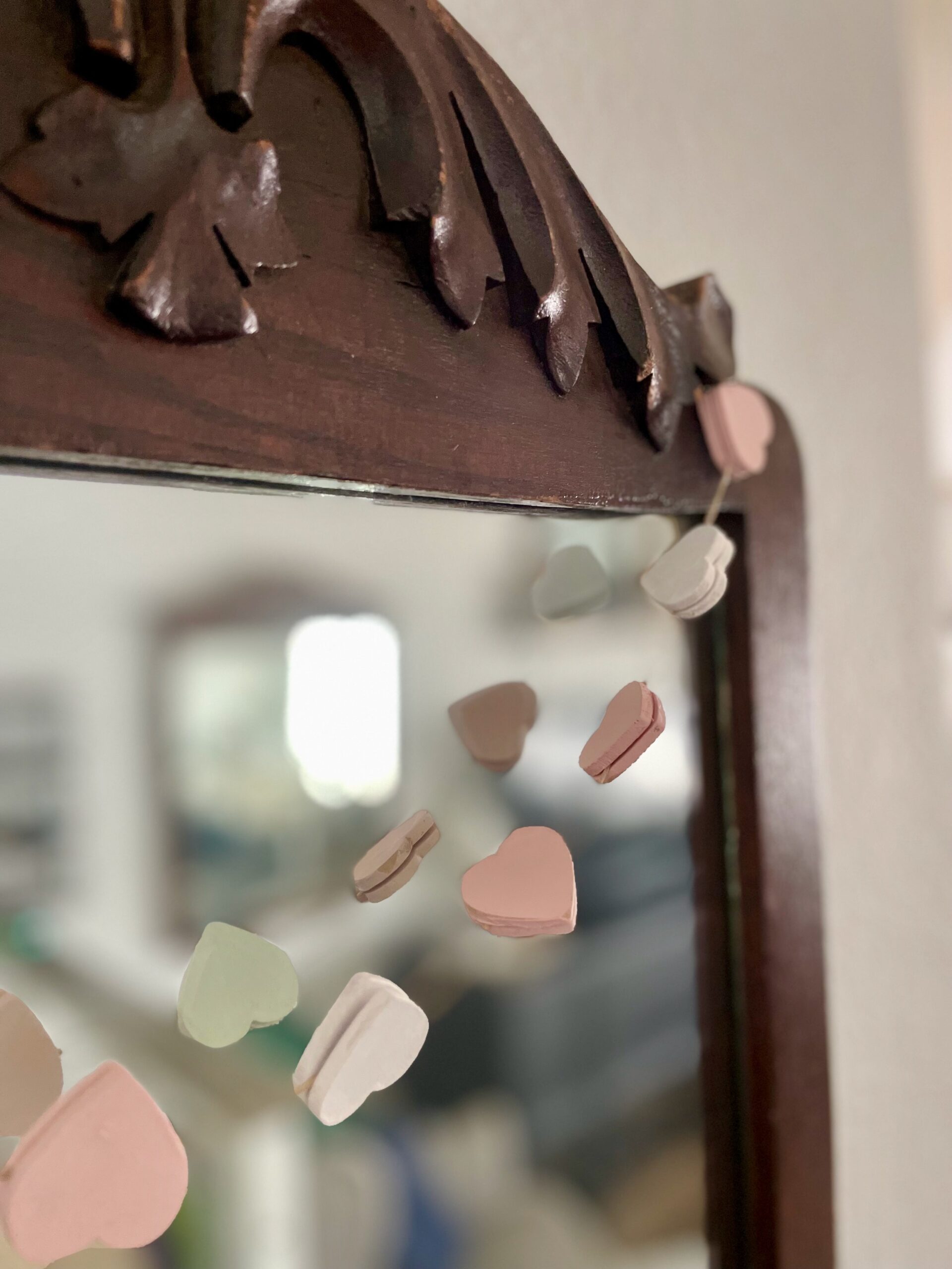 wooden hearts on a garland displayed on an antique mirror