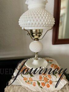 a vintage linen with orange flowers underneath a lamp