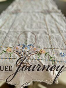 a vintage table runner with an embroidered basket