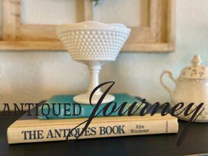 a vintage milk glass bowl in the middle of a shelf with vintage books