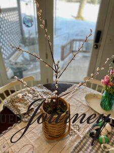 a faux pussy willow stem in a basket as an Easter tree