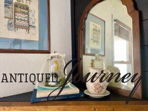 a Spring cloche displayed on a mantel with vintage books, Ironstone, and transferware
