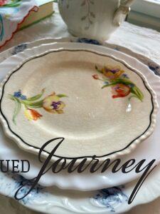 a vintage Tulip plate on a stack of other vintage plates